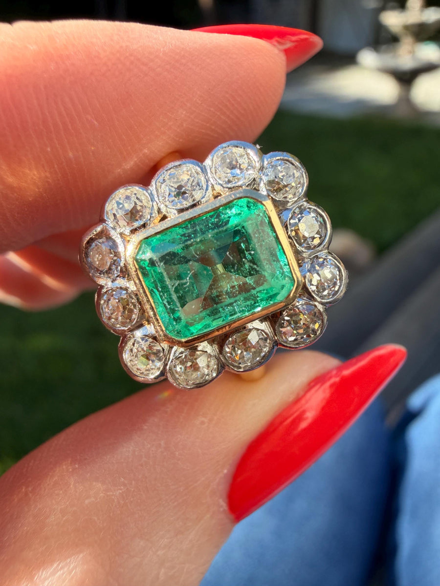 Antique natural emerald and old European cut diamond halo ring in 18 karat yellow gold